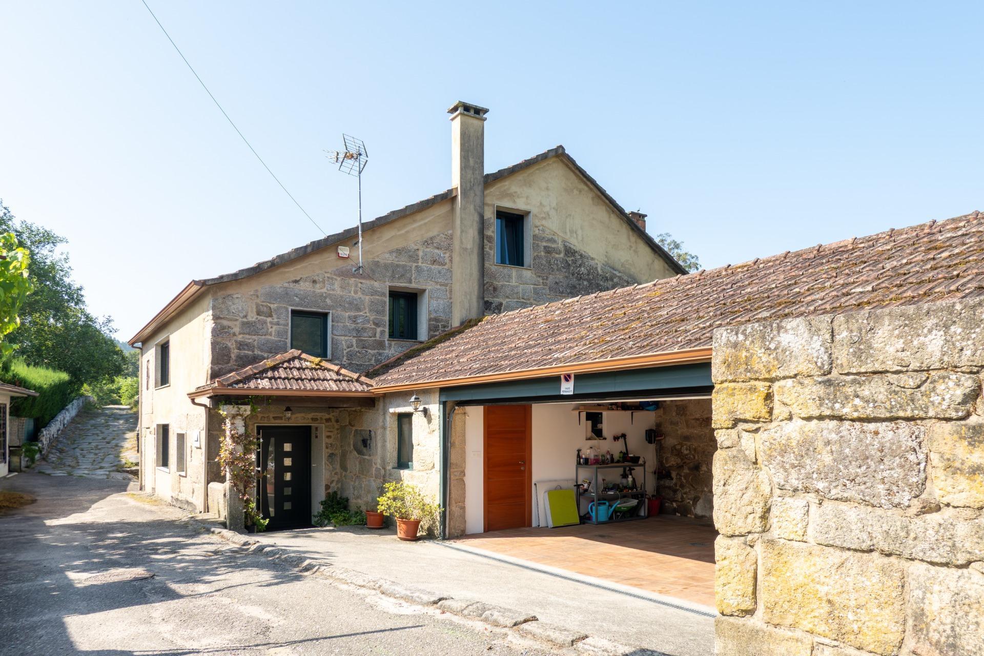 Casa de piedra reformada con jardín frente al puente romano de Cernadela (Mondariz)