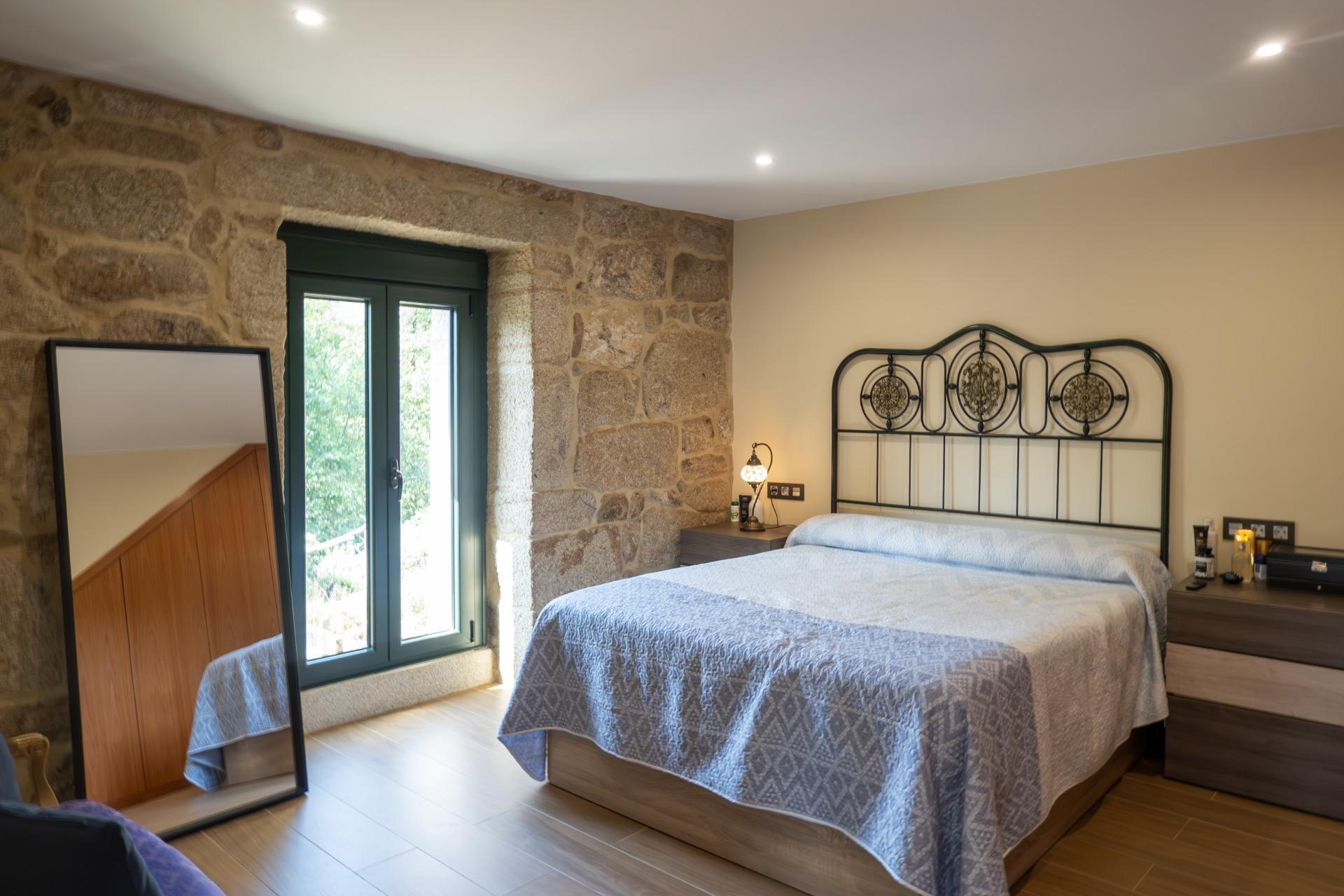 Casa de piedra reformada con jardín frente al puente romano de Cernadela (Mondariz)